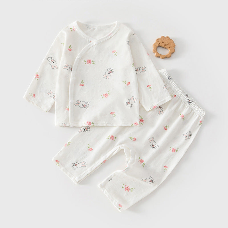 Baby-Set mit Blumen und kleinen Hasen neben einem Holzspielzeug