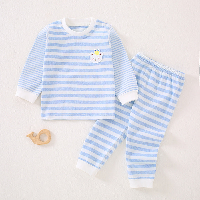 Hellblau gestreiftes Baby-Set neben einem Holzspielzeug
