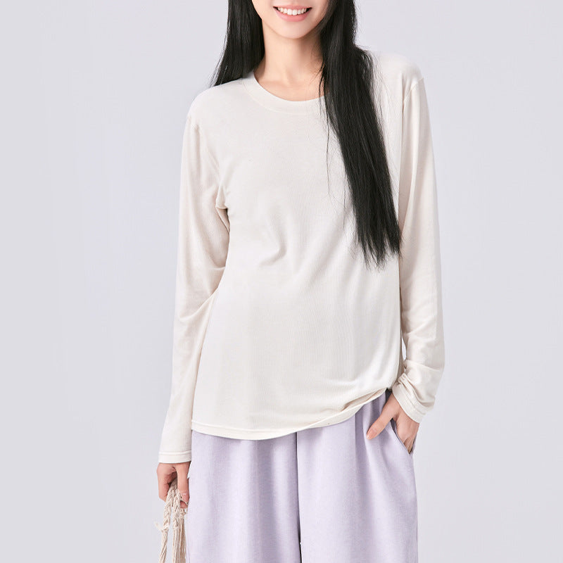 Frau in cremefarbenem Langarmshirt, Hand in der Hosentasche