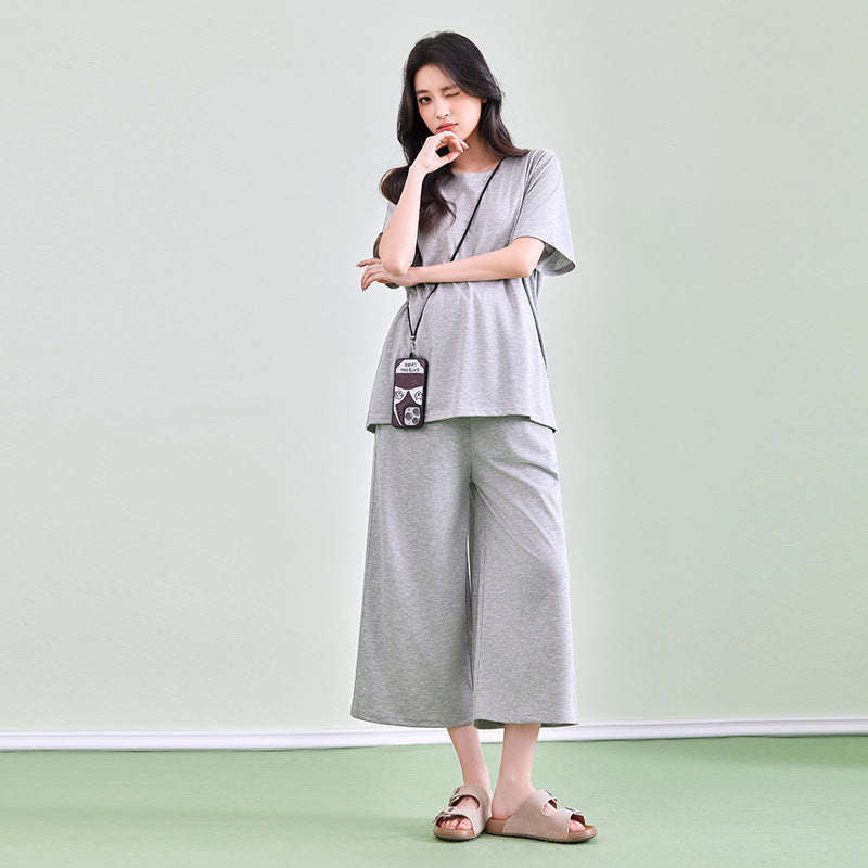 Frau in hellgrauem Shirt und weiter Hose