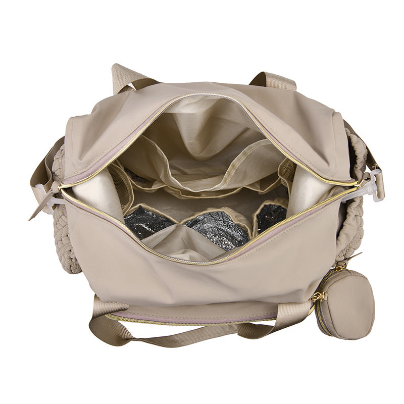 Geöffnete beigefarbene Wickeltasche mit Blick auf die Innenfächer
