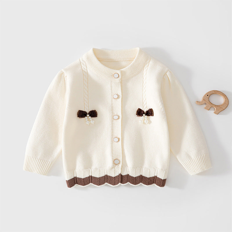 Cremefarbene Strickjacke mit zwei braunen Schleifen