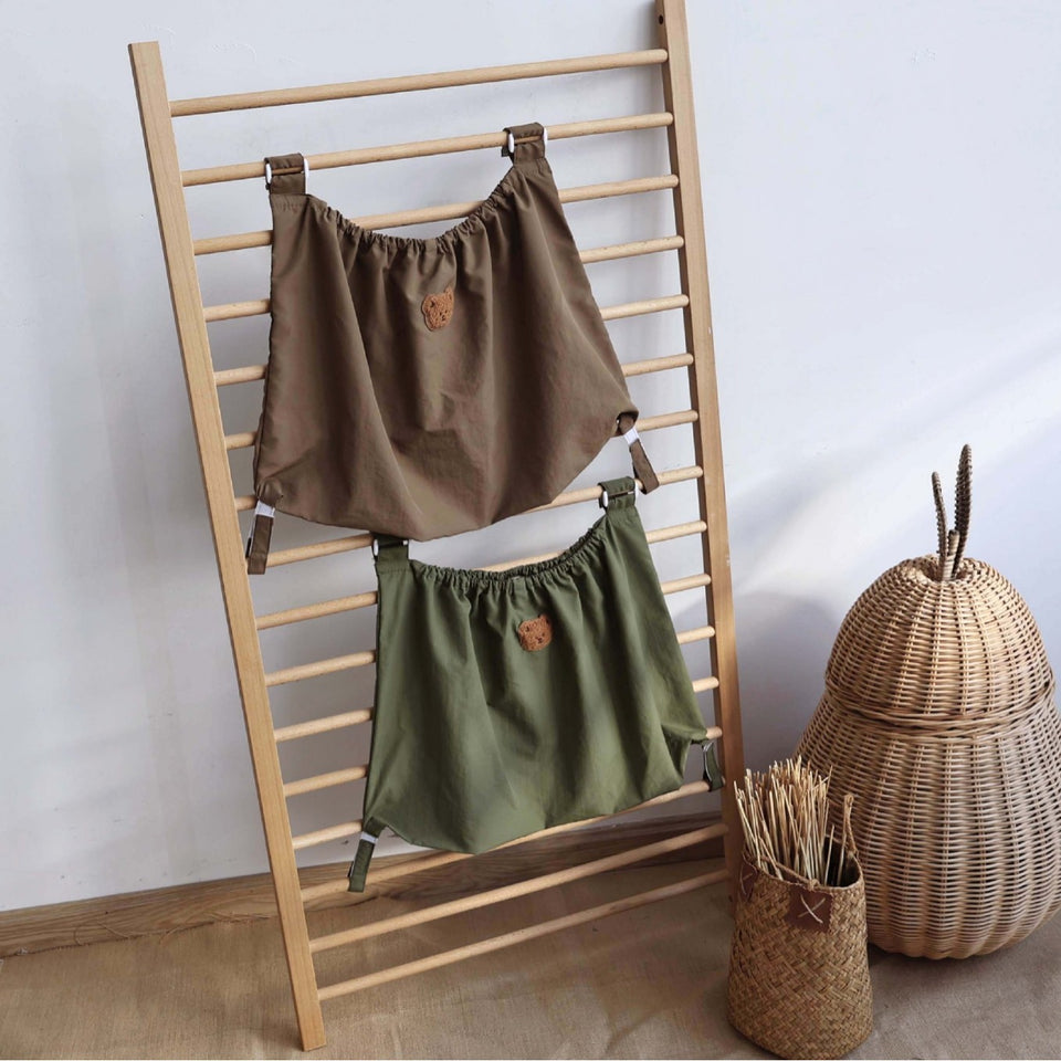 Zwei Netztaschen in Beige und Grün an einer Leiter eingehängt