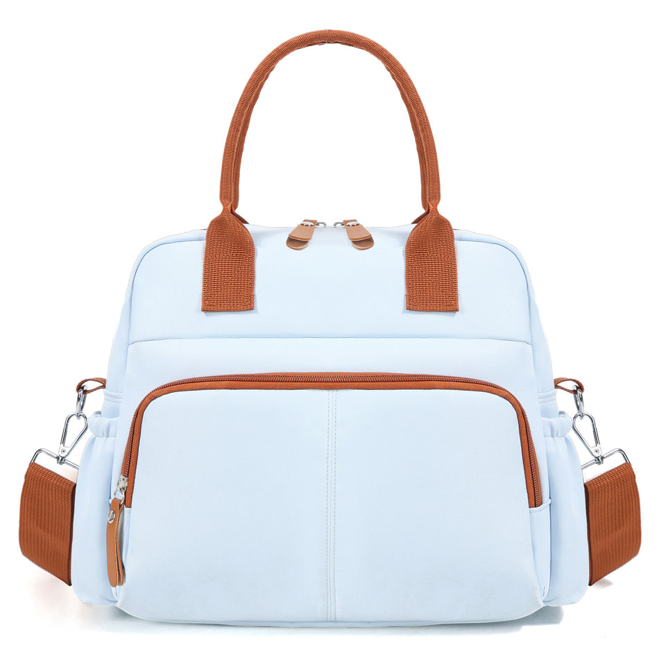 Hellblaue Wickeltasche mit braunen Griffen und Fronttasche