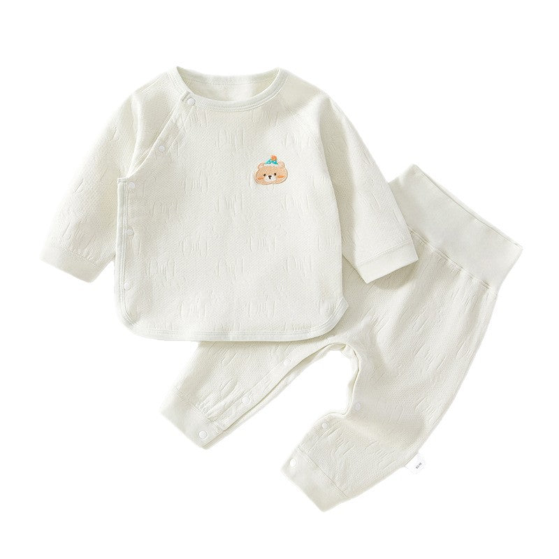 Weißgrünes Baby-Set mit Wickeljacke und Hose mit hohem Bund auf weißem Grund