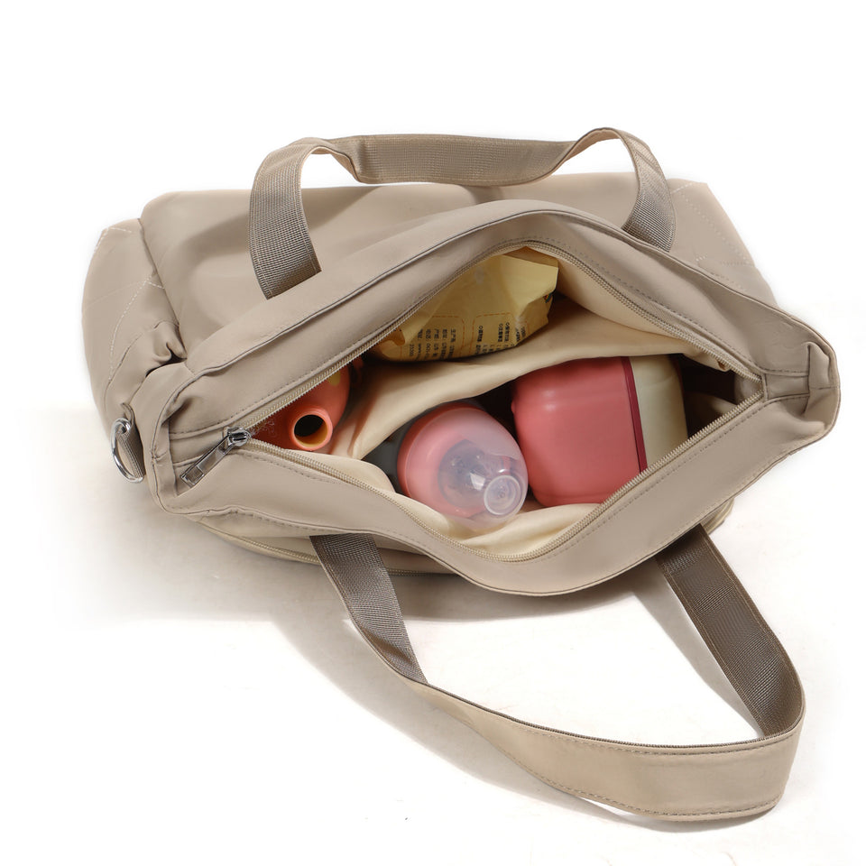 Geöffnete Wickeltasche mit Fläschchen und Dose im Innenraum
