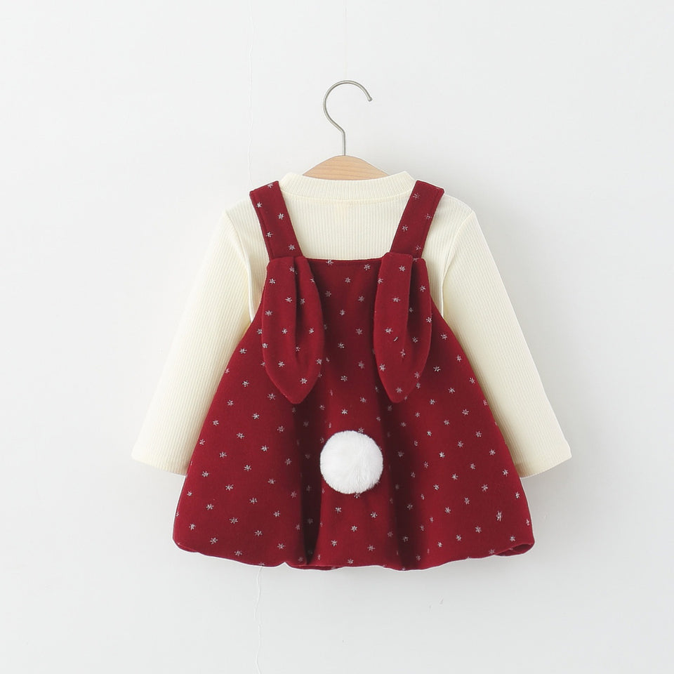 Rotes Trägerkleid mit Hasenohren und Bommelschwanz auf dem Rücken über cremefarbenem Langarmshirt