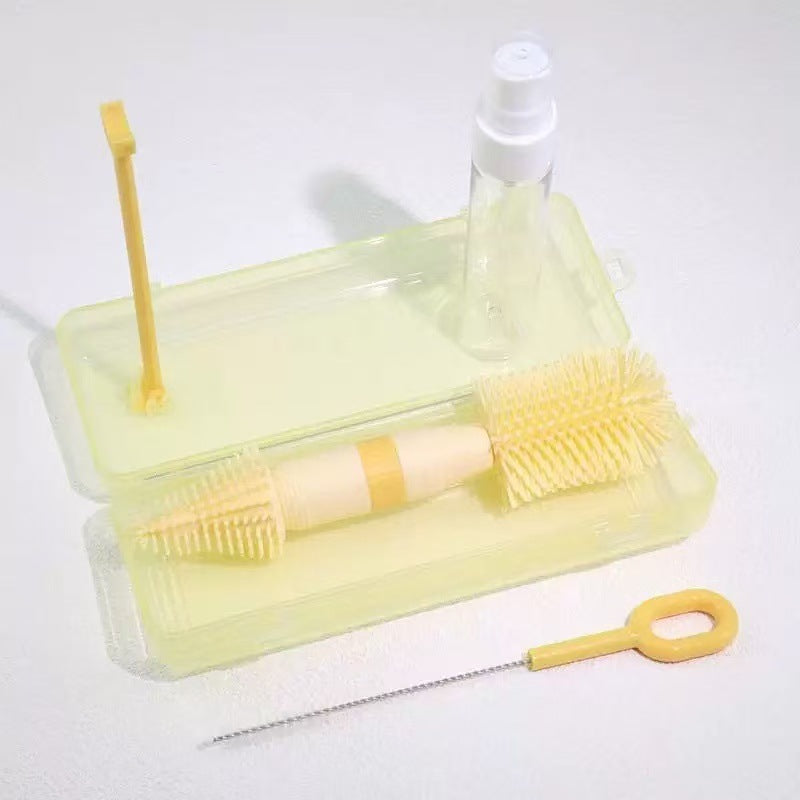 Flaschenbürste aus Silikon mit Box in Gelb, daneben eine dünne Bürste und eine kleine Pumpflasche