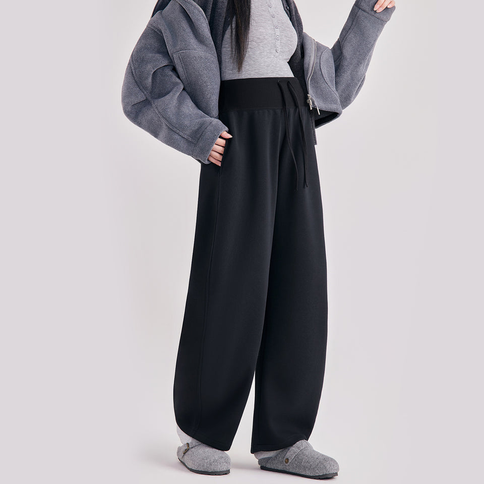 Frau in schwarzer Umstandshose in Ballonform, dazu graue Jacke
