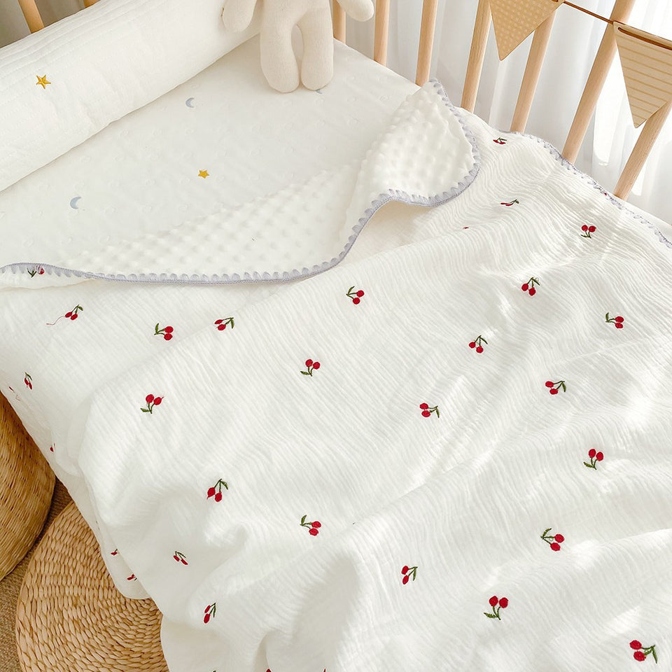 Weiße Babydecke mit gestickten roten Kirschen