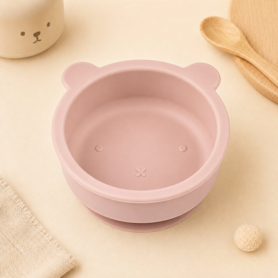 Bären-Schüssel aus Silikon in Rosa neben Holzlöffeln