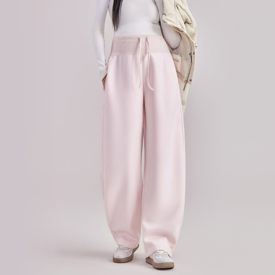 Frau in rosa Umstandshose in Ballonform, dazu helle Jacke