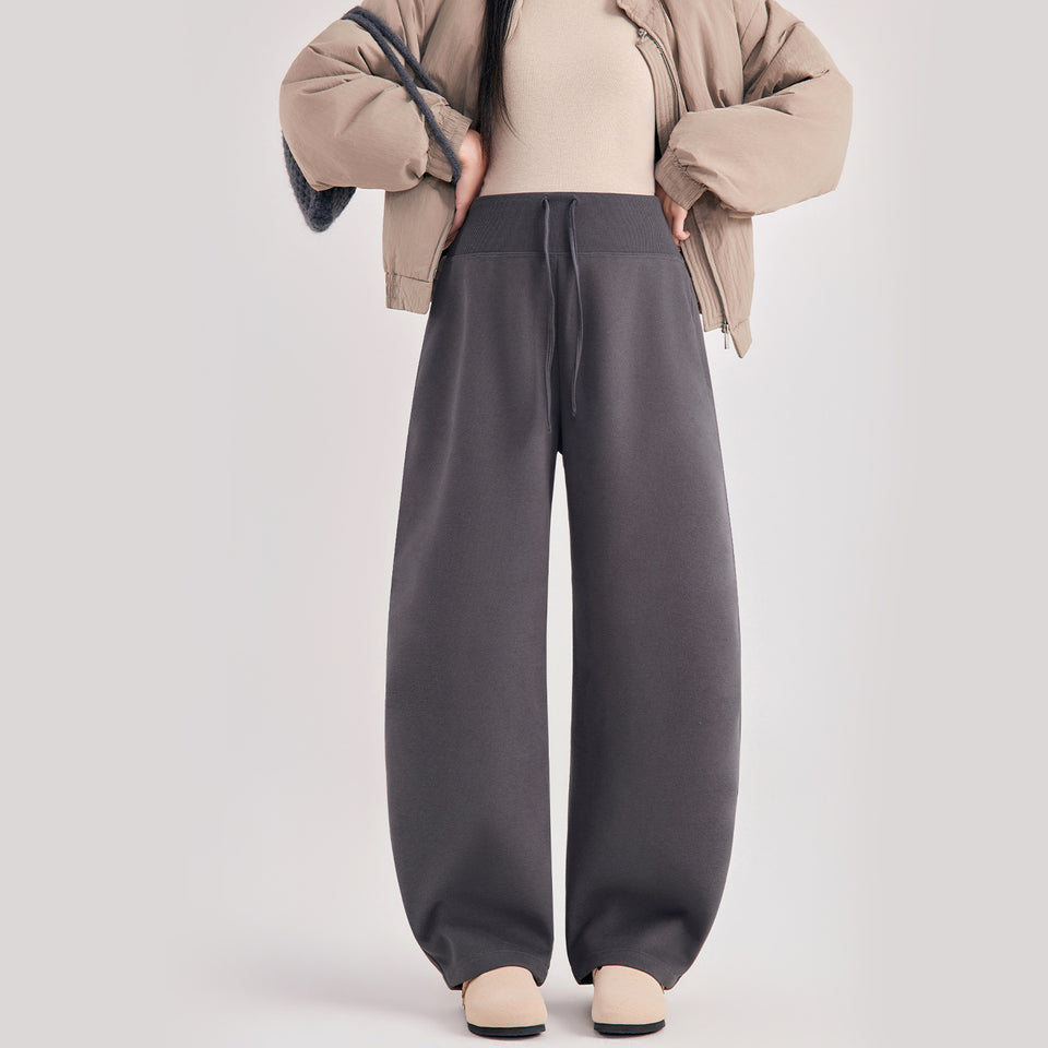 Frau in dunkelgrauer Umstandshose in Ballonform, dazu beige Jacke