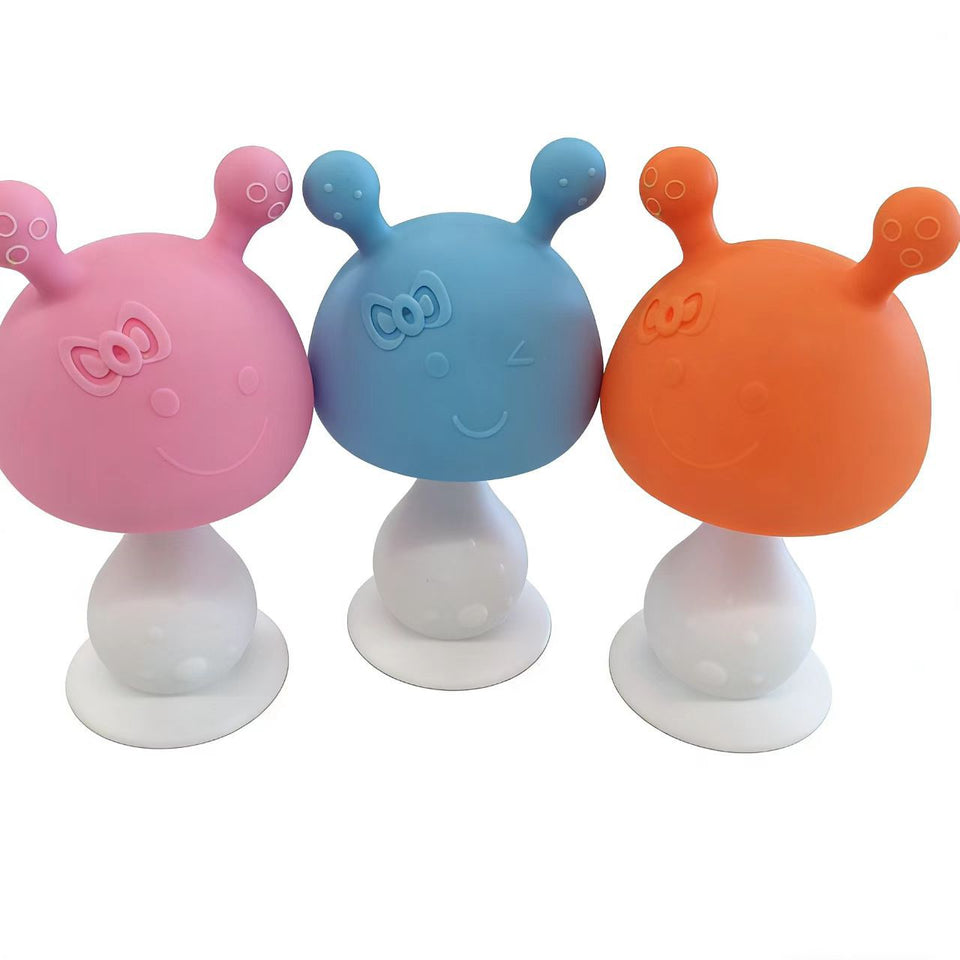 Drei Beißpilze aus Silikon in Rosa, Blau und Orange mit weißem Saugfuß