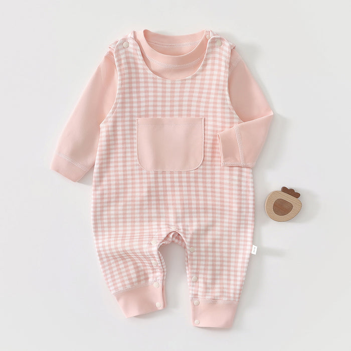 Rosa karierter Baby-Strampler im Latzhosen-Look neben einem Holzspielzeug