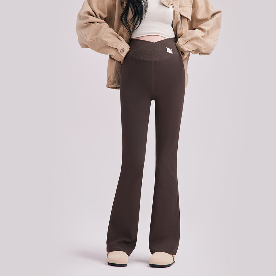 Frau in brauner Umstandshose mit ausgestelltem Bein und V-Bund, dazu beige Jacke
