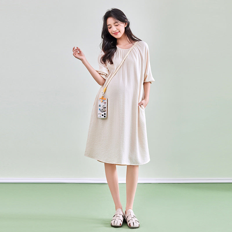 Frau in cremefarbenem Kleid mit Raffung