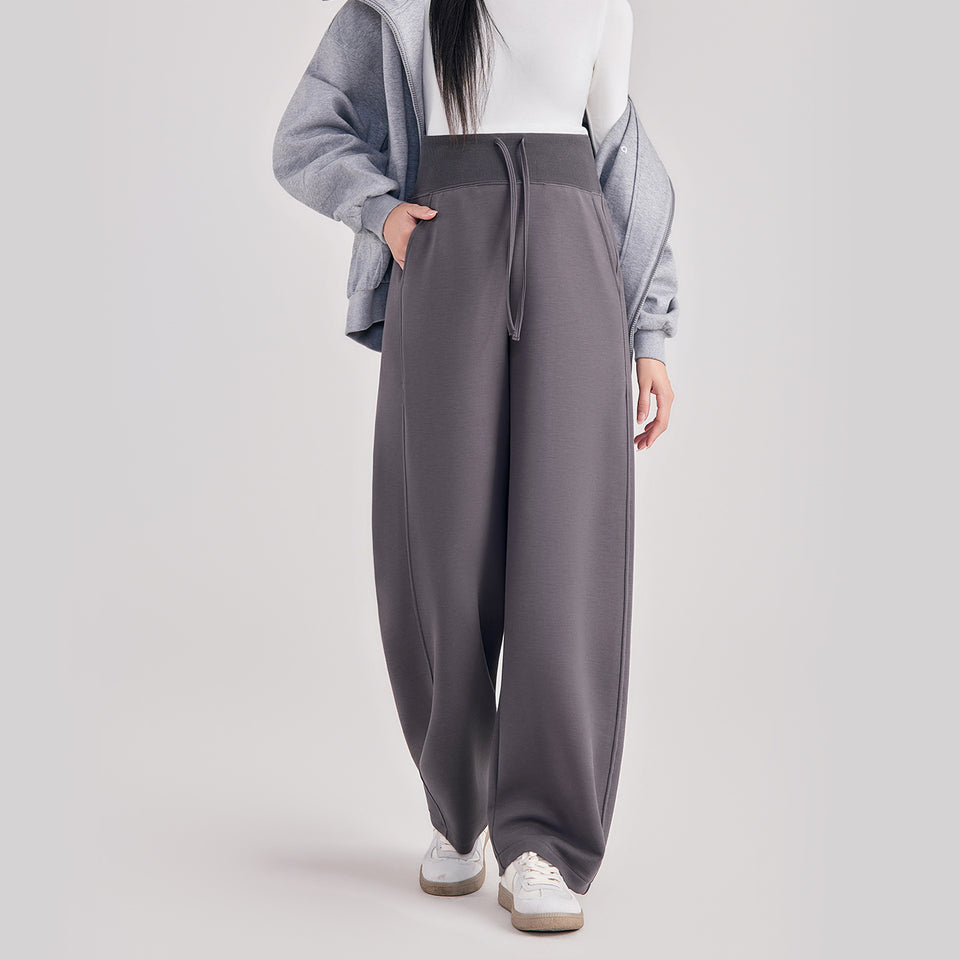 Frau in grauer weiter Umstandshose mit breitem Bund und Kordel, dazu blaue Jacke