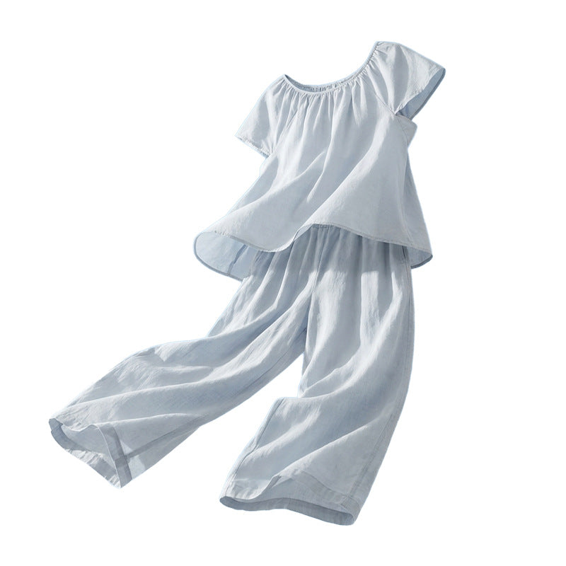Hellblaues Set aus Raffbluse und weiter Hose freigestellt