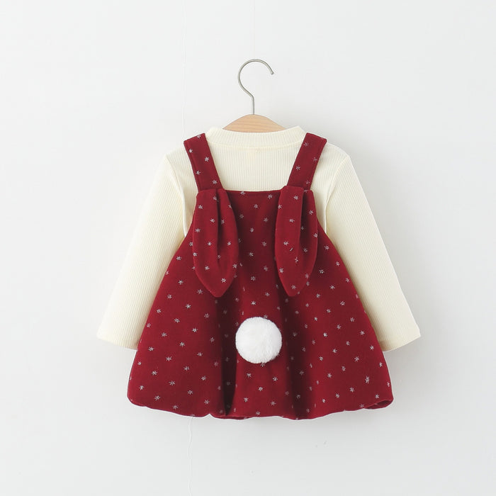 Rotes Trägerkleid mit Hasenohren und Bommelschwanz auf dem Rücken über cremefarbenem Langarmshirt