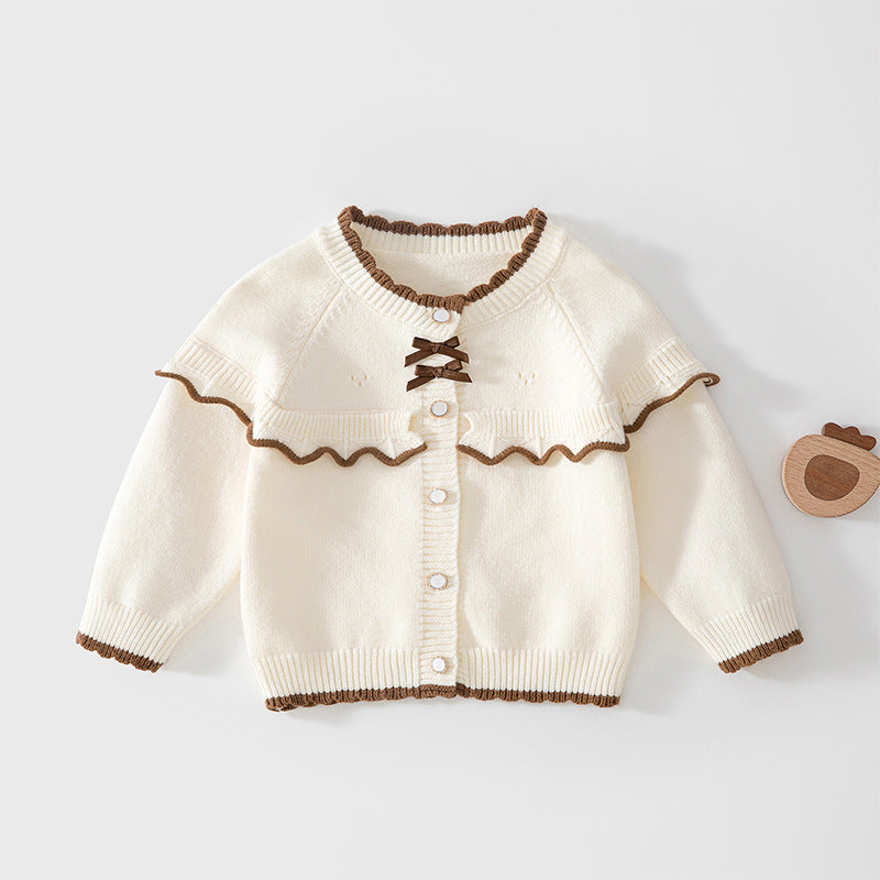Cremefarbene Strickjacke mit Rüschenkragen und kleiner brauner Schleife