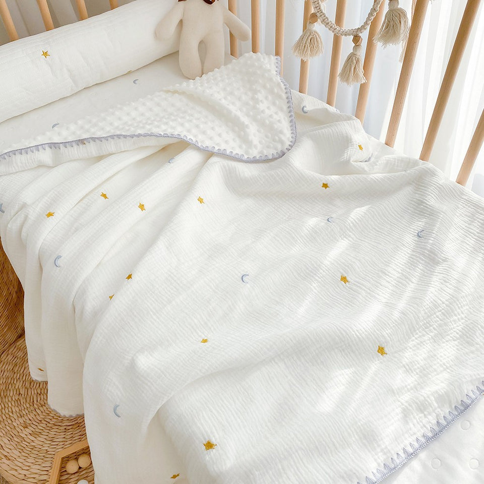 Weiße Babydecke mit gelben gestickten Monden und Sternen