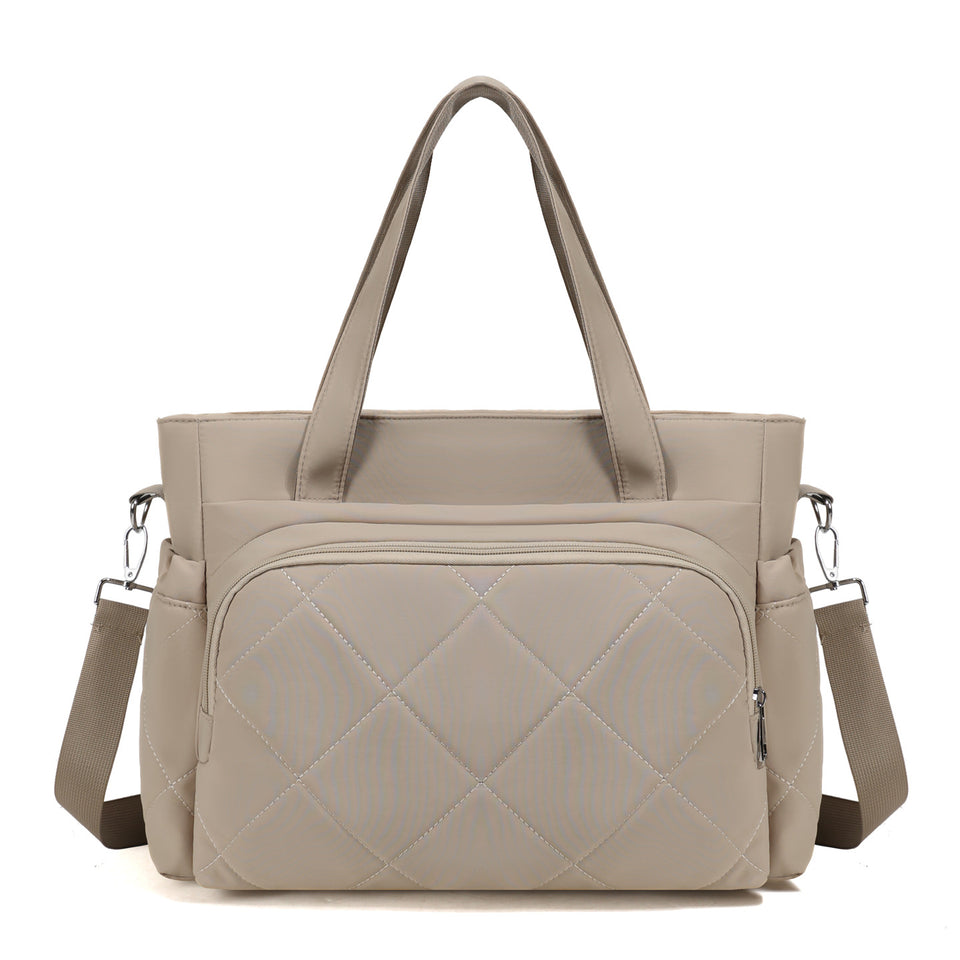 Beigefarbene Wickeltasche mit Rautensteppung, Henkeln und Schultergurt