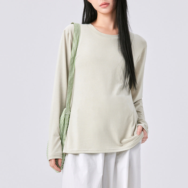 Frau in mintgrünem Langarmshirt mit Tasche