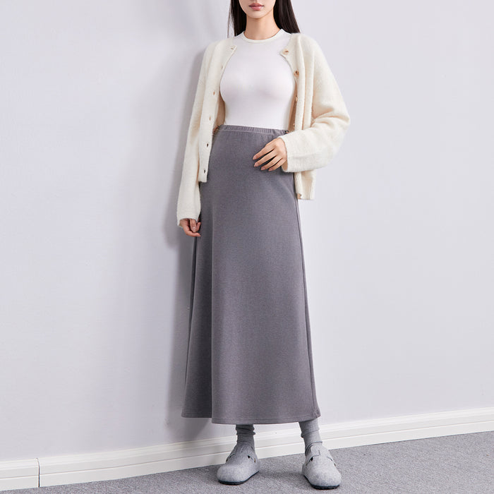Frau in grauem langen Umstandsrock mit heller Strickjacke